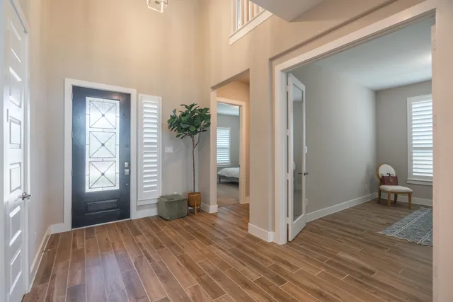 a view of empty room with window and wooden floor