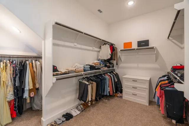 a view of walk in closet with clothes and shoes