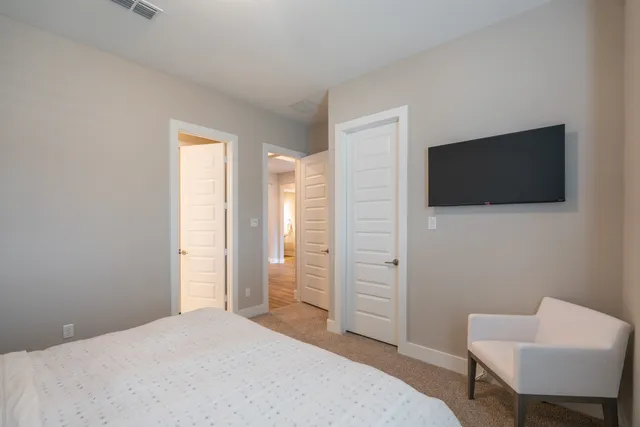 a bedroom with a bed tv and chair