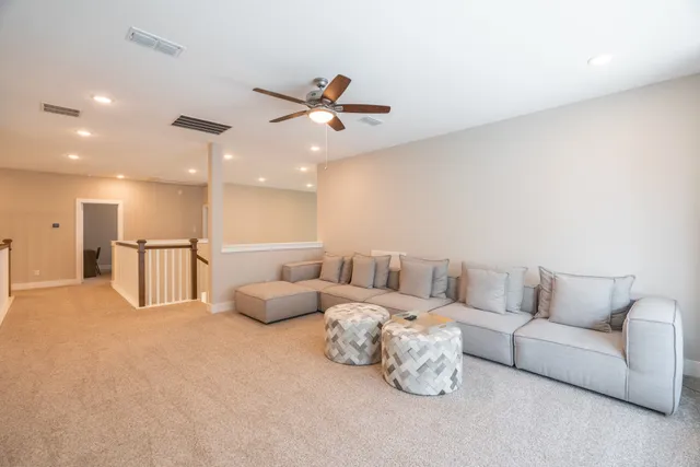 a living room with furniture and a ceiling fan