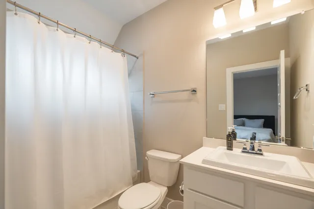 a bathroom with a sink a toilet and shower curtain
