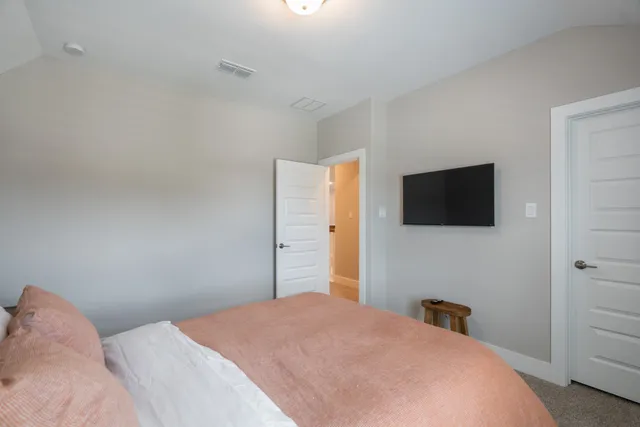 a bedroom with a bed and a flat screen tv