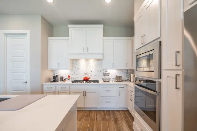 a kitchen with stainless steel appliances a stove microwave and cabinets