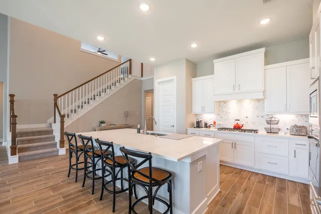 a kitchen with a dining table chairs sink and cabinets