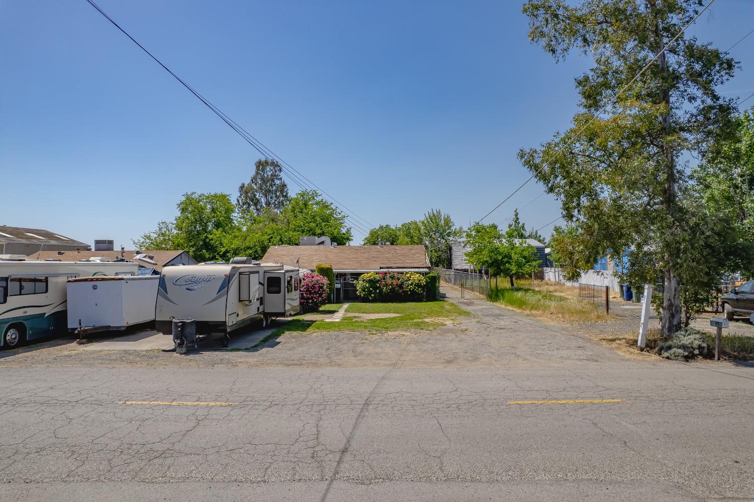 6849 26th Street Rio Linda, CA 95673 - Photo 48 of 56 a backyard of a house with table and chairs under an umbrella