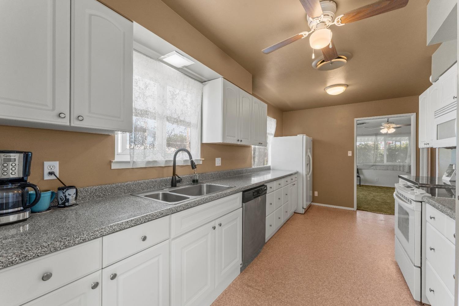 6849 26th Street Rio Linda, CA 95673 - Photo 5 of 56 a kitchen with granite countertop a sink a counter space appliances and cabinets