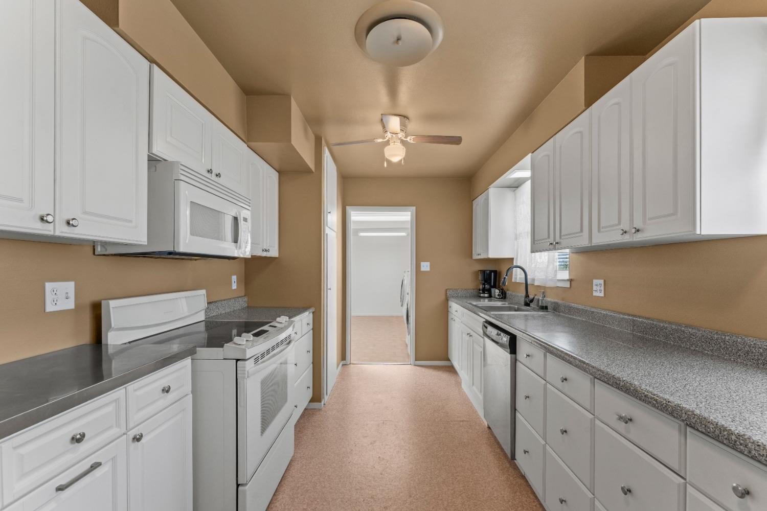 6849 26th Street Rio Linda, CA 95673 - Photo 6 of 56 a kitchen with granite countertop a sink dishwasher refrigerator stove and cabinets