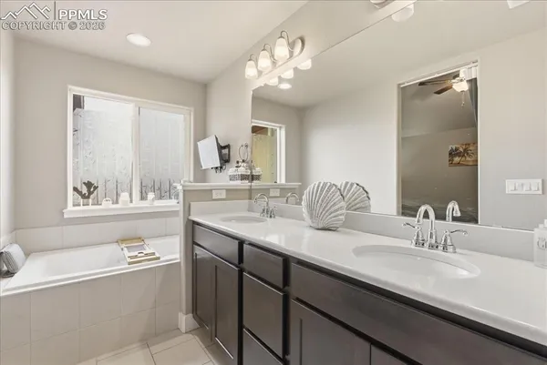 a bathroom with a tub double sink and mirror