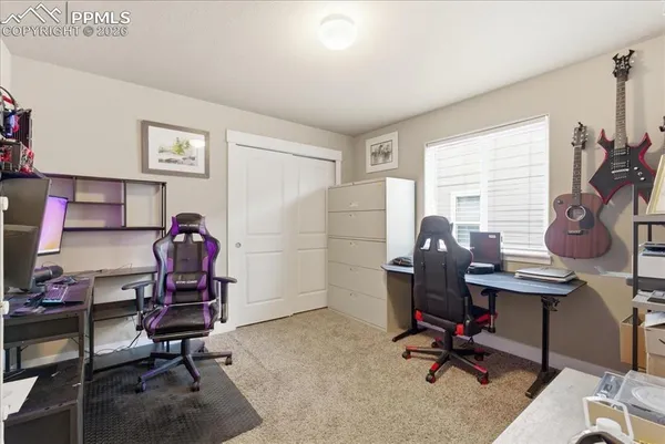 a view of a workspace with furniture and a window