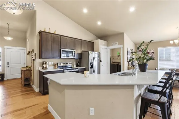 a kitchen with kitchen island a counter top space appliances and cabinets