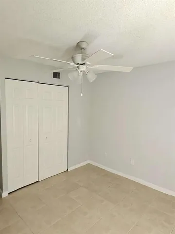 an empty room with a ceiling fan and a window