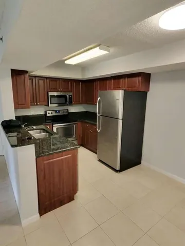 a kitchen with stainless steel appliances granite countertop a refrigerator stove and microwave
