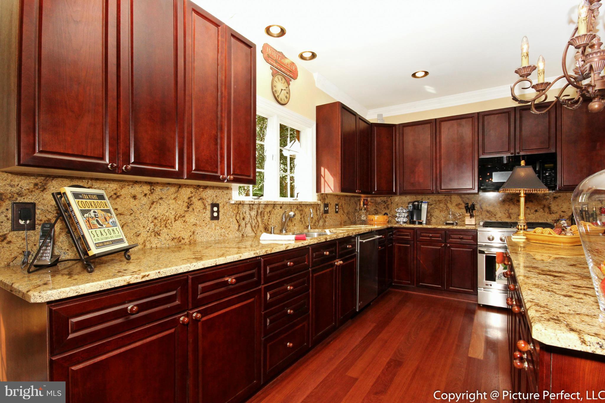 5380 Stone Road Frederick, MD 21703 - Photo 13 of 30 a kitchen with a sink and wooden cabinets