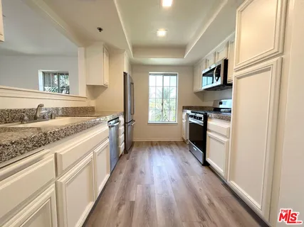 a kitchen with stainless steel appliances granite countertop a stove a sink and a refrigerator