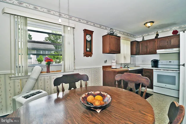 a kitchen with stainless steel appliances wooden floor dining table and chairs