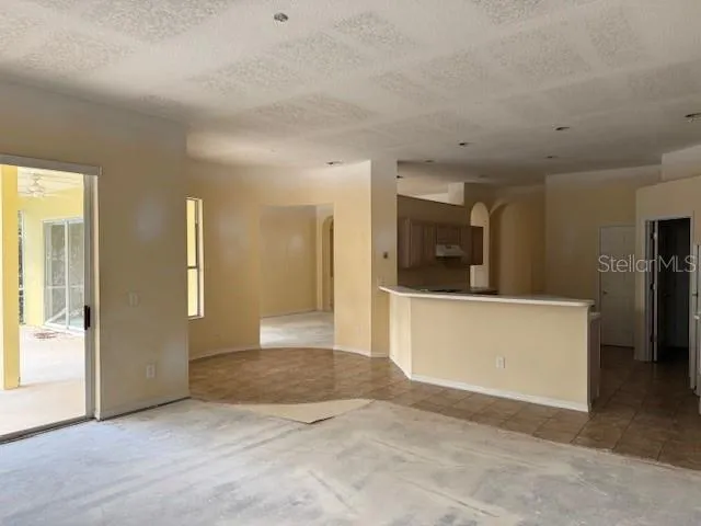 a view of a big room with wooden floor and a kitchen
