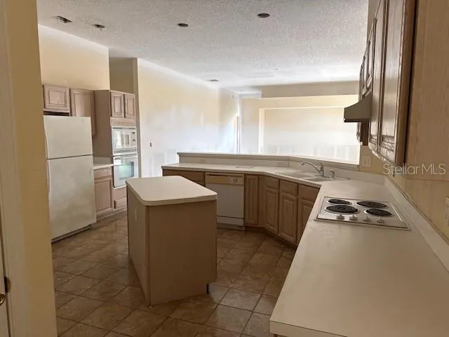 a kitchen with a sink stove and refrigerator