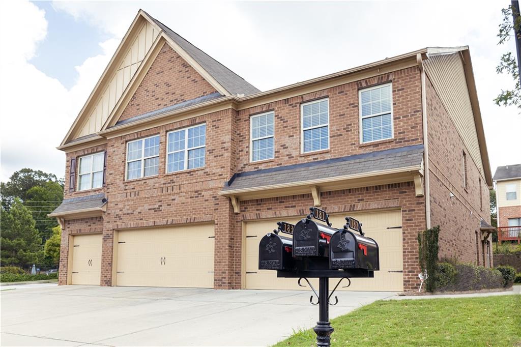 a view of a brick house with many windows and a yard