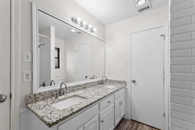 a bathroom with a granite countertop sink and a mirror