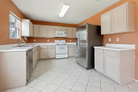 a kitchen with a sink a refrigerator and cabinets