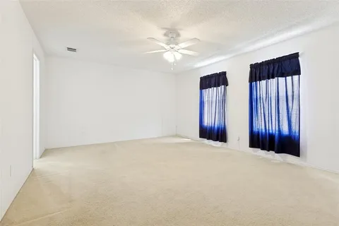 a view of an empty room with a ceiling fan