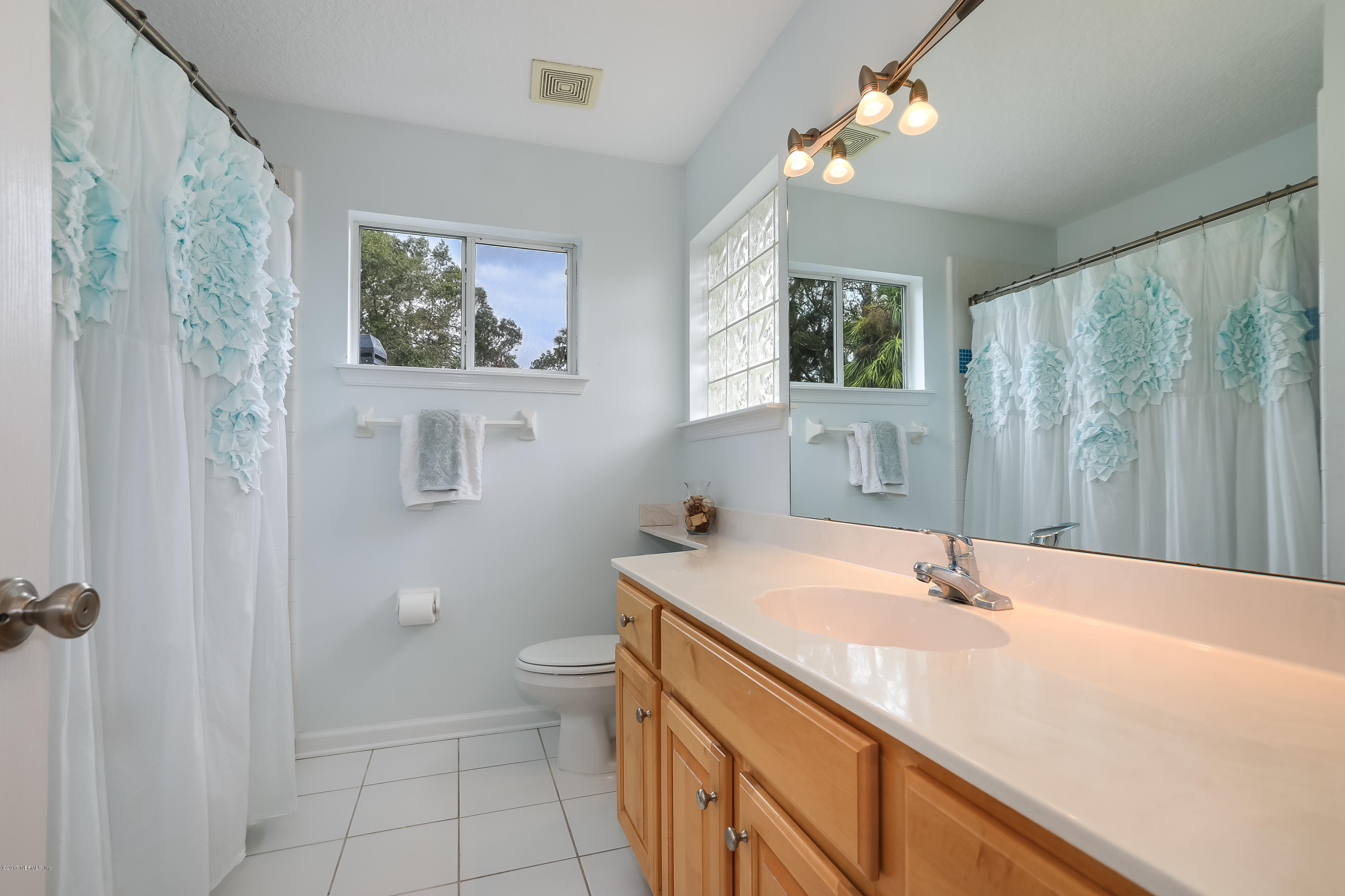 489 Big Tree Road Ponte Vedra Beach, FL 32082 - Photo 21 of 32 a bathroom with a sink a toilet and a large mirror