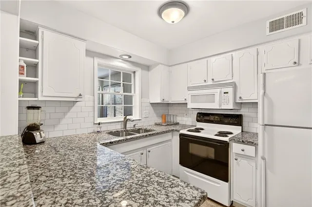 a kitchen with a sink stove and white cabinets
