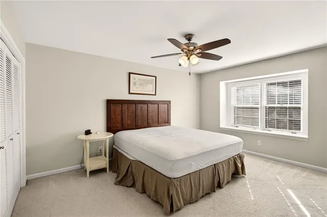 a spacious bedroom with a bed a window and closet