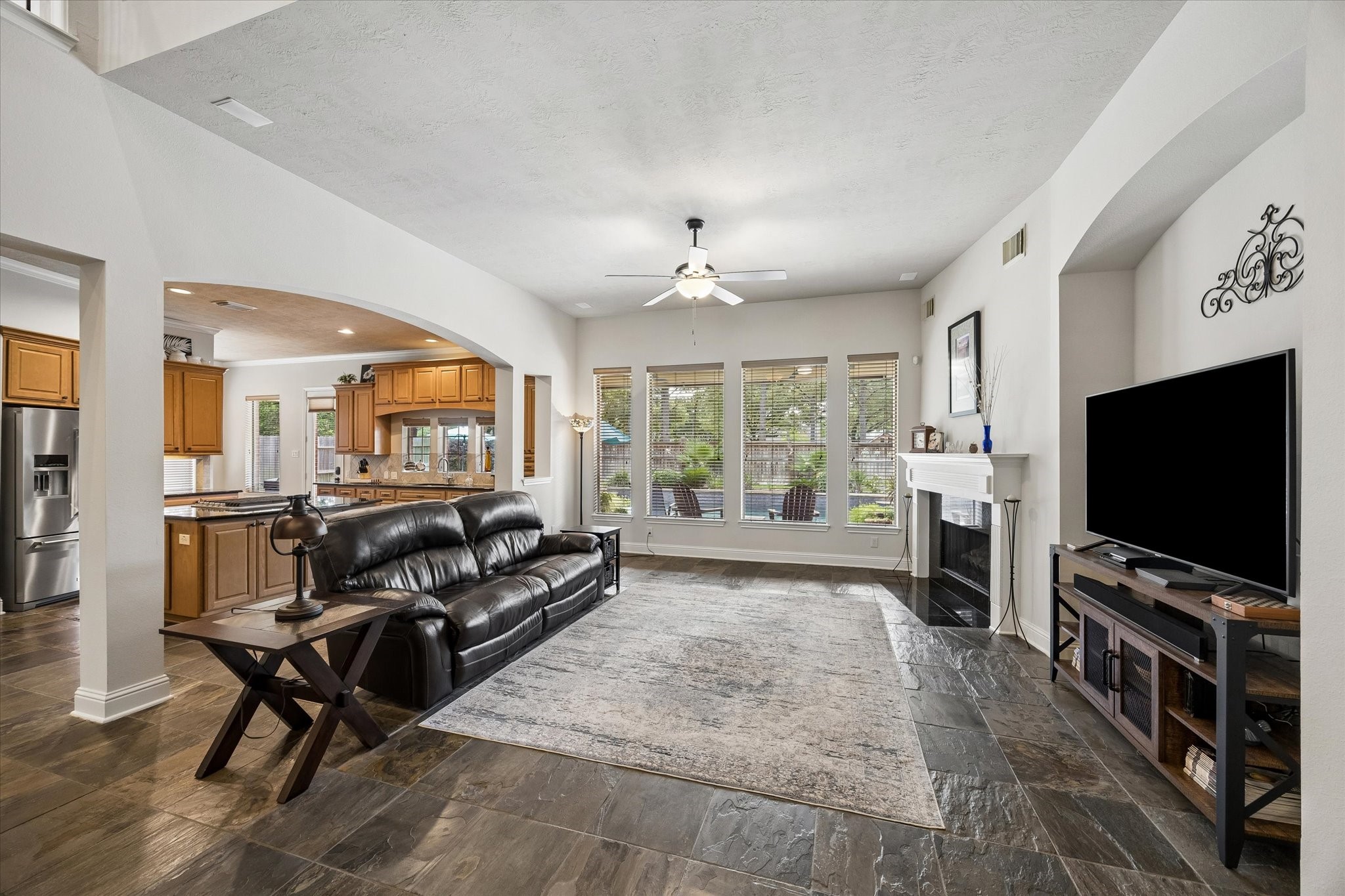 3902 Trailstone Lane Katy, TX 77494 - Photo 12 of 50 The family room offers a cozy setting for quiet evenings in, gatherings with family and friends, and the kind of space that turns ordinary moments into something special, all with a charming gas log fireplace, slate tile flooring, and plenty of room to spread out and relax.