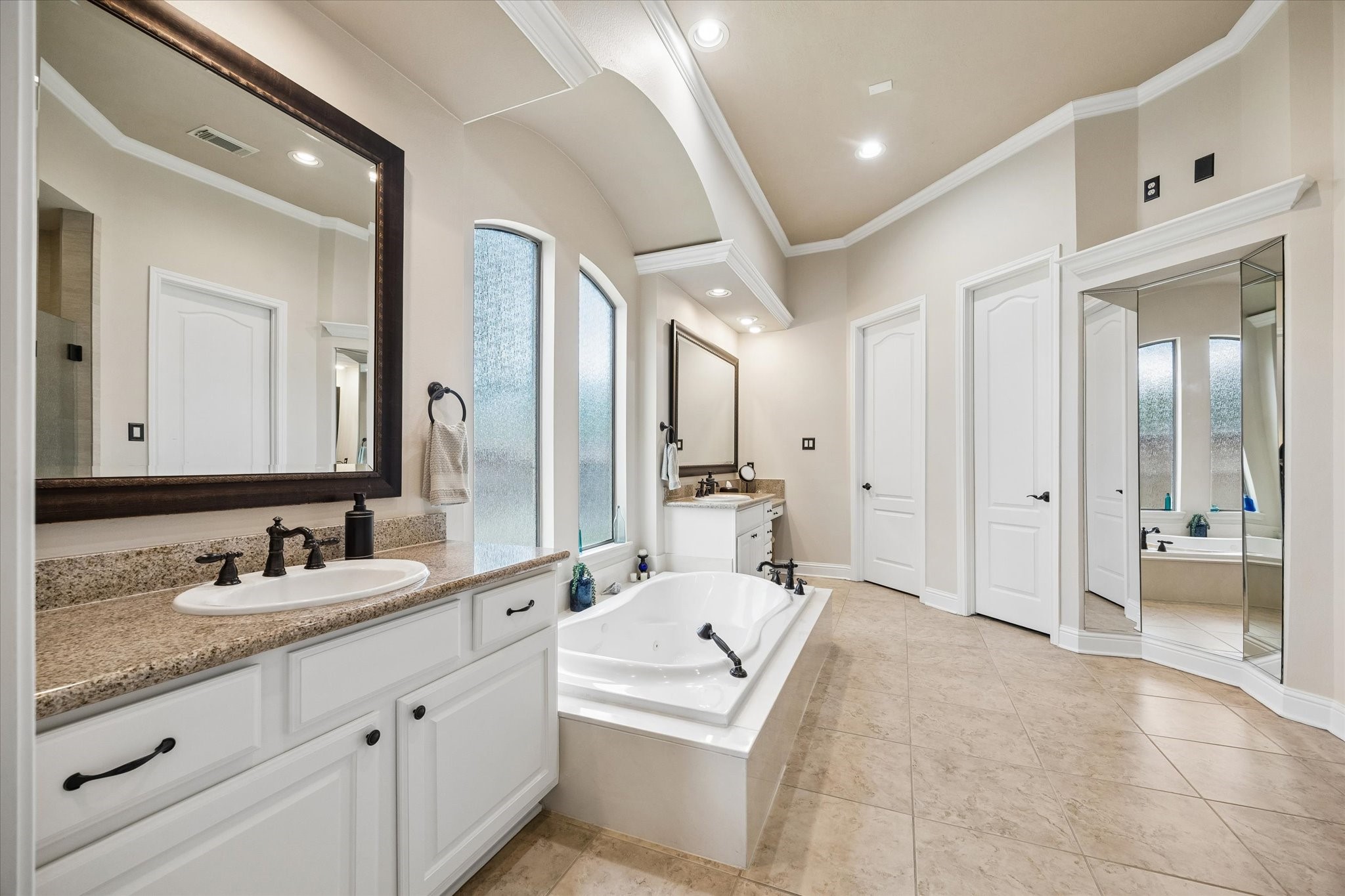 3902 Trailstone Lane Katy, TX 77494 - Photo 22 of 50 Enjoy a daily dose of luxury in this spectacular ensuite with a deep jetted tub, two separate vanities, a walk-in closet, full dressing mirrors, two walk-in closets, and a private water closet.