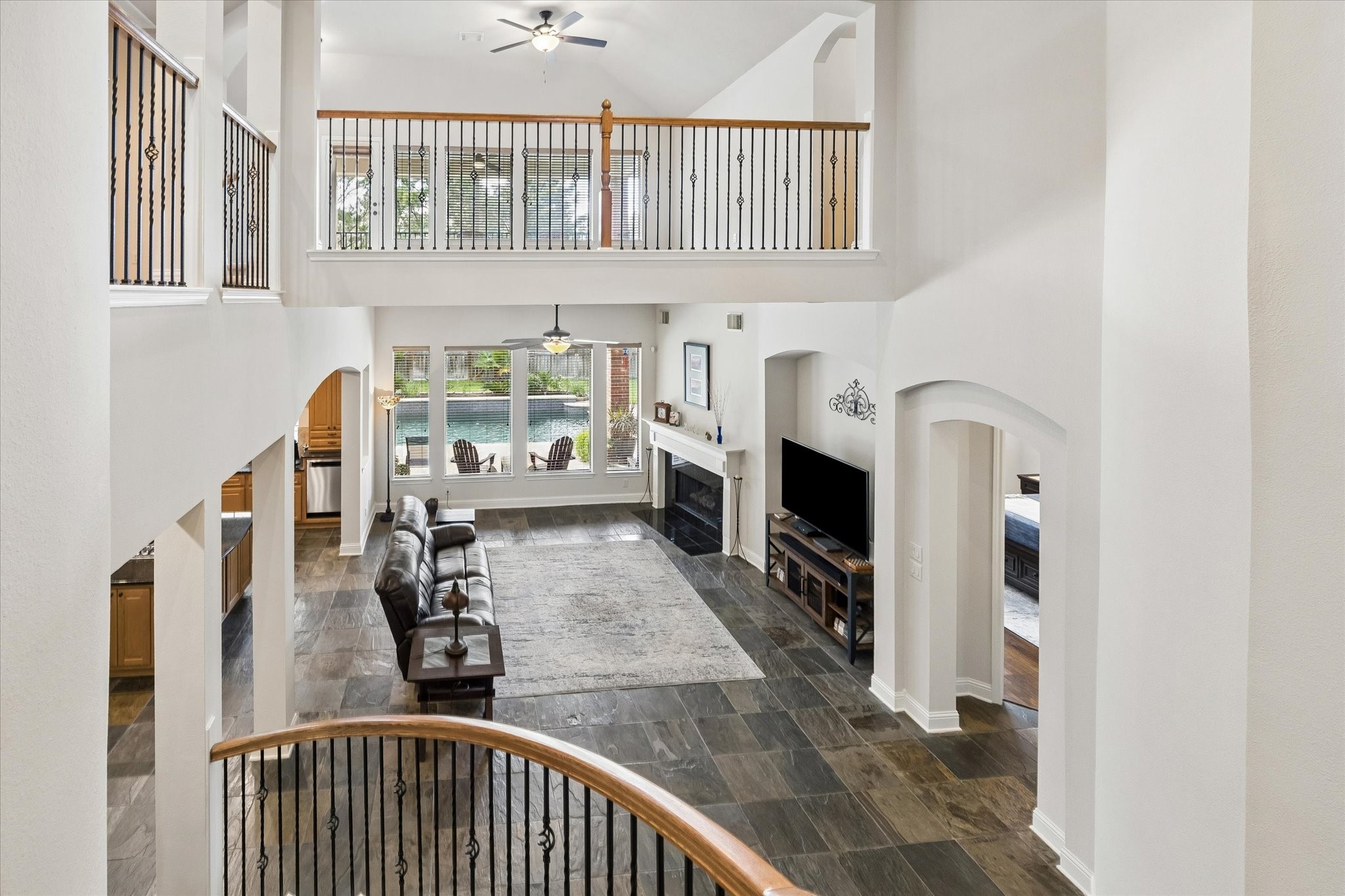 3902 Trailstone Lane Katy, TX 77494 - Photo 25 of 50 Impressive from every angle, this stunning home feels open, airy, and beautifully connected, with soaring spaces, abundant natural light by day, and a warm glow that feels just as inviting after sunset. From the dramatic foyer and elegant entertaining spaces to the spacious family room, beautifully designed kitchen, private owner’s retreat, and backyard made for unforgettable evenings, every inch was designed to be enjoyed. This is the kind of home that feels grand, welcoming, and memorable all at once, and
