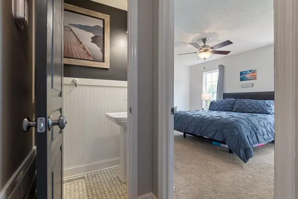 a bedroom with a bed and a painting on the wall