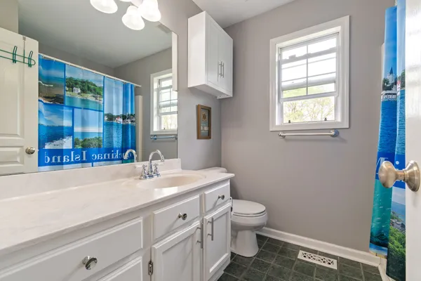 a bathroom with a sink a toilet and a window