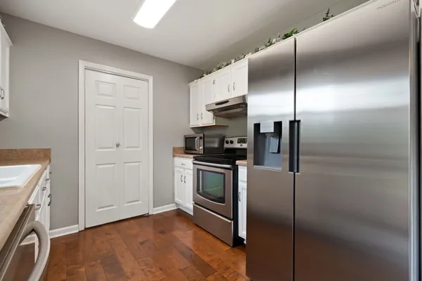 a kitchen with white cabinets and appliances