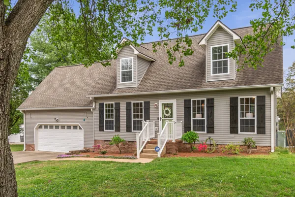 a view of a house with a yard and sitting area