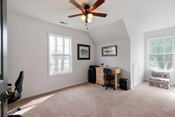 a bedroom with a bed ceiling fan and a large mirror