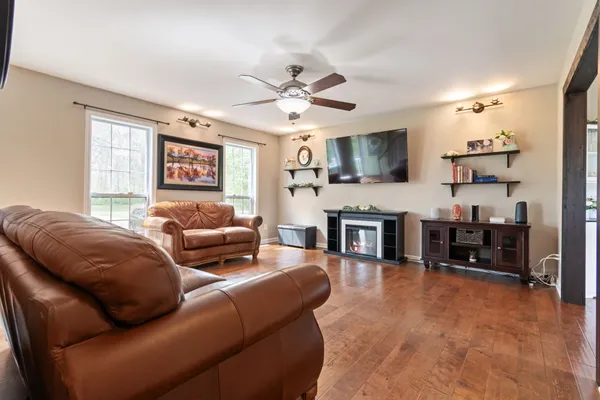 a living room with furniture kitchen view and a flat screen tv