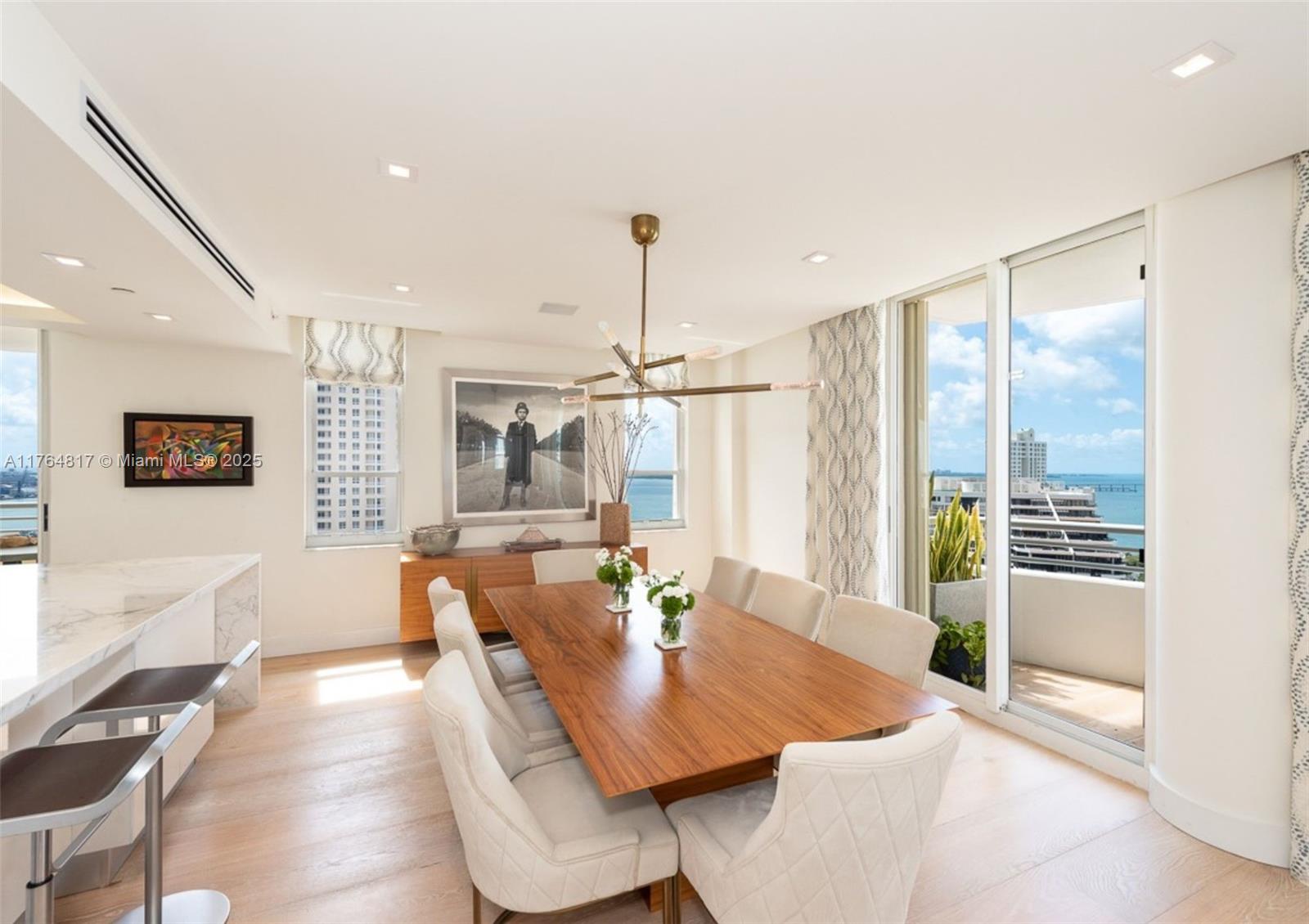 888 Brickell Key Drive, Unit 2501 Miami, FL 33131 - Photo 3 of 39 a view of a dining room with furniture window and wooden floor