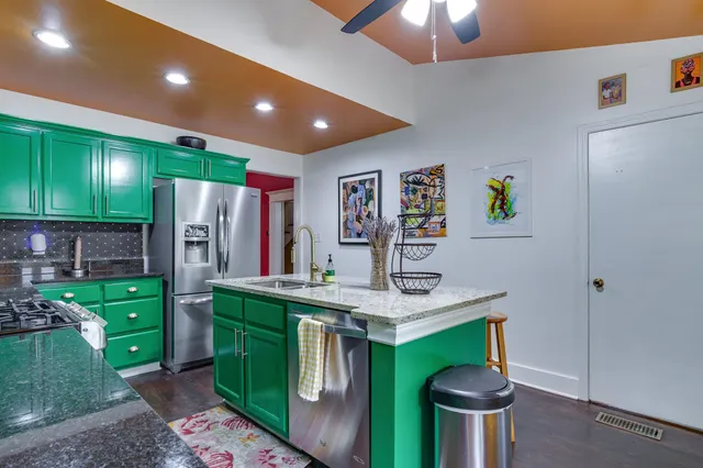 a kitchen with stainless steel appliances kitchen island granite countertop a refrigerator and a stove top oven