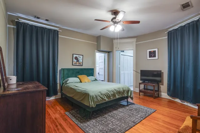 a spacious bedroom with a bed and a flat screen tv