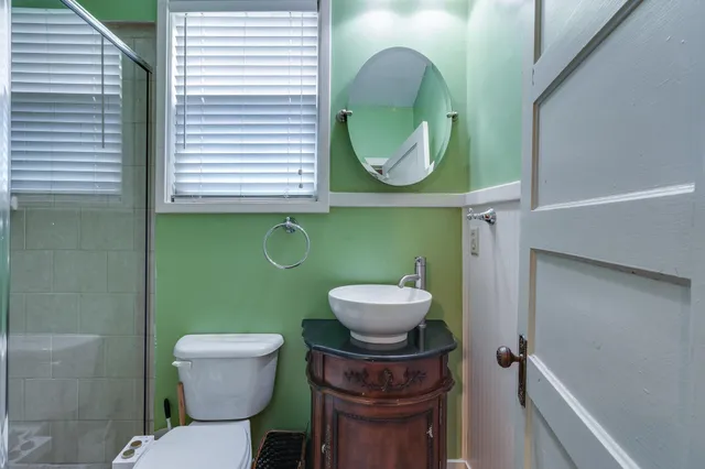 a bathroom with a toilet a sink and mirror