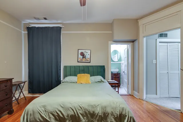 a bed sitting in a bedroom next to a cabinet and mirror