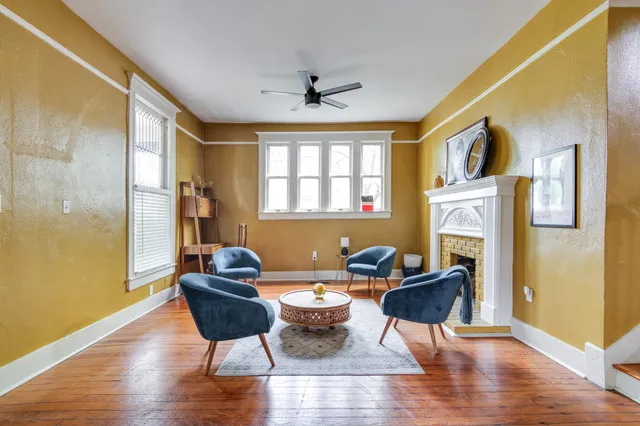 a living room with fireplace furniture and a window
