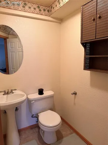 a bathroom with a toilet a sink and mirror