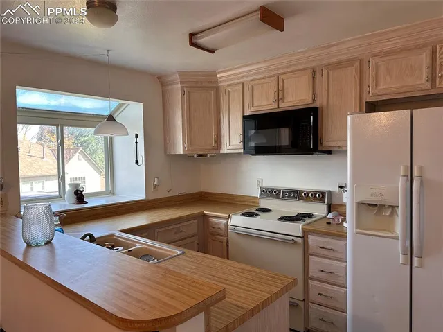 a kitchen with a appliances a window and a counter top space