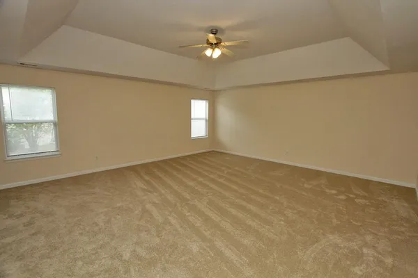 an empty room with closet and a ceiling fan