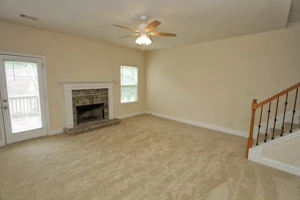 an empty room with windows and fireplace