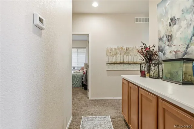 a view of hallway with a large mirror and a sink