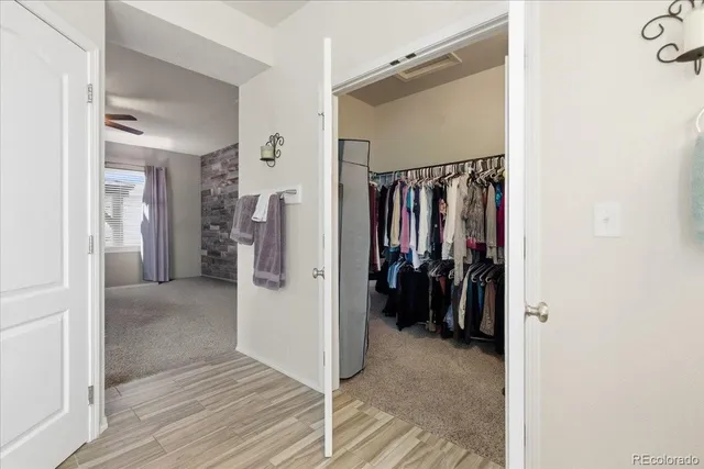 a view of walk in closet with clothes and shoes