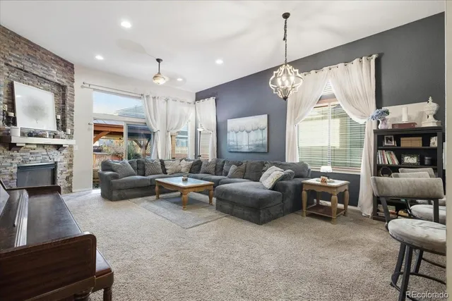 a living room with furniture fireplace and a large window